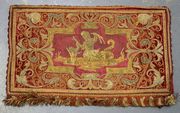A late 17th/early 18th Century Italian embroidered and appliqué panel with a design of a mermaid holding a fish, within a foliate and strapwork border with fringe edgings, approx 26cm x 46cm.