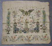 A late 18th Century needlework panel, possibly of Turkish manufacture, with a design of a lady flanked by pavilions within a stylized garden with butterfly and various insects, worked in silk threads on a cream canvas ground, approx 34cm x 36cm.