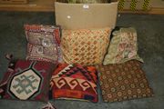 Two Persian carpet covered cushions and a collection of other cushions.