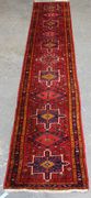 A Hamadan runner, North-west Persia, late 20th Century, the red field with hooked medallions and guls, within a blue complimentary border, approx 370cm x 72cm.