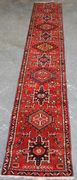 A Hamadan runner, North-west Persia, late 20th Century, the red field with hooked medallions, within a blue flowerhead and vine border, approx 435cm x 72cm.