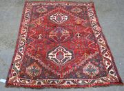 A Hamadan rug, North-west Persia, 20th Century, the red field with three stepped medallions, within an ivory and leaf border, approx 168cm x 122cm.