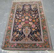 A Central Persian part silk prayer rug, late 20th Century, the deep blue field with an ascending flower-charged vase populated by birds, below a hanging basket and two boteh, within a green complimentary border, approx 185cm x 115cm.