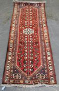 A Hamadan runner, North-west Persia, 20th Century, the red field with ivory lobed medallions and an ascending flowering vine, within an ivory border, approx 198cm x 69cm.