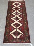 A Hamadan runner, North-west Persia, late 20th Century, the ivory field with a single column of stepped guls, within a brown flowering vine border.