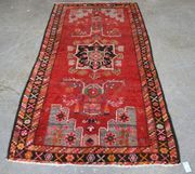 A Hamadan rug, North-west Persia, mid-20th Century, the red field with a central medallion, stylized lanterns and grey spandrels, within a charcoal border, approx 250cm x 127cm.