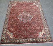 A Tabriz rug, North-west Persia, mid-20th Century, the red field with a lobed foliate medallion supported by overall herati, within an ivory palmette and flowering vine border, approx 165cm x 116cm.