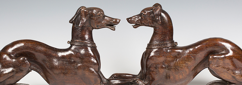 pair of impressive carved oak single-sided models of facing recumbent greyhounds
