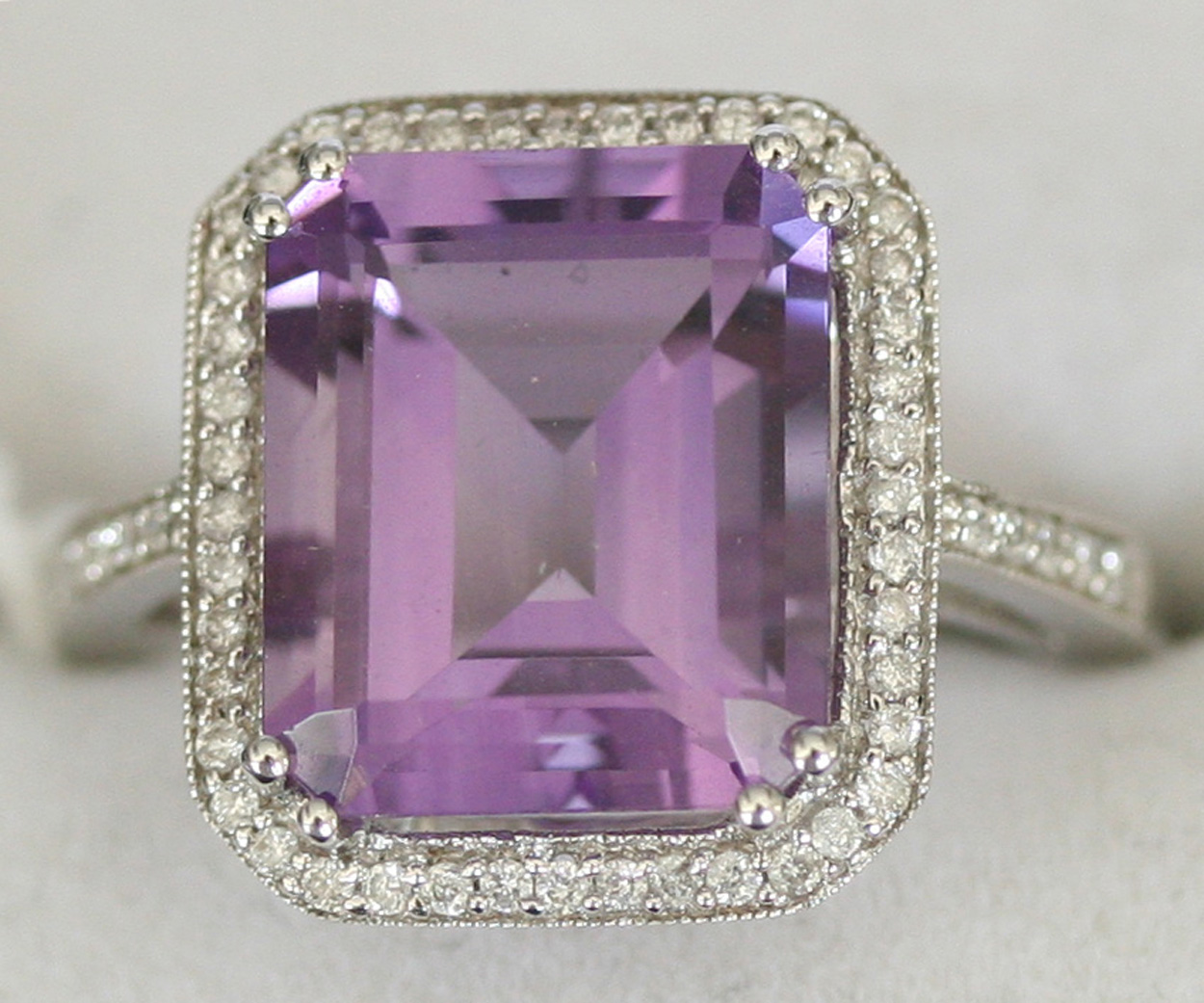 An amethyst and diamond ring, claw set with the cut cornered ...