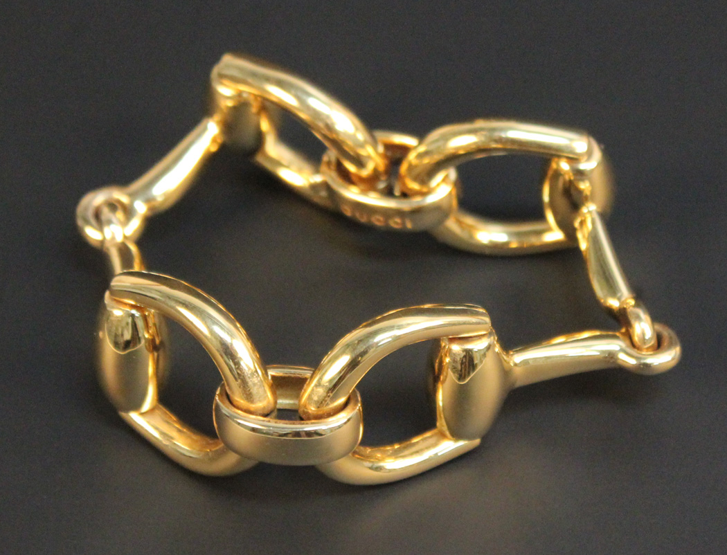 A Gucci gold bracelet in a twin horse's bit shaped design, with a ...