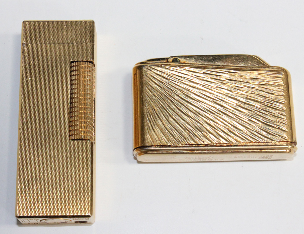 A Dunhill gilt metal rectangular cigarette lighter with all-over engine ...