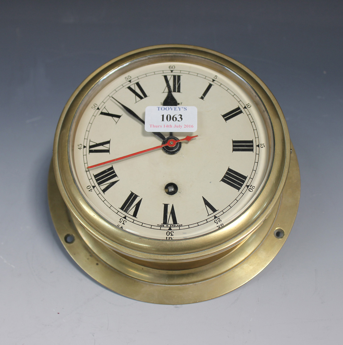 A mid-20th Century brass cased ships clock, the circular painted dial with  Roman numerals and slow/f