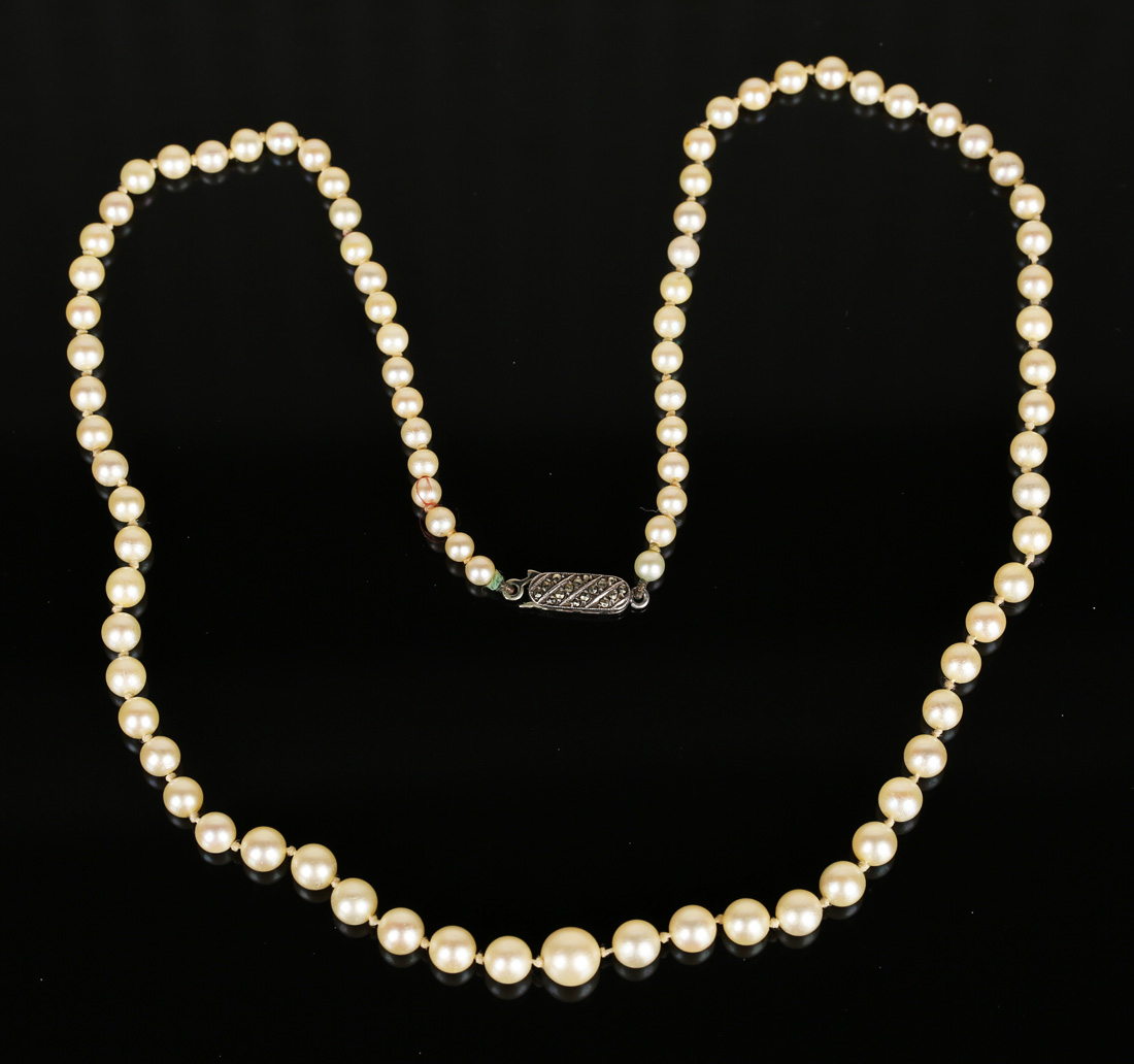 A single row necklace of graduated cultured pearls on a marcasite set ...