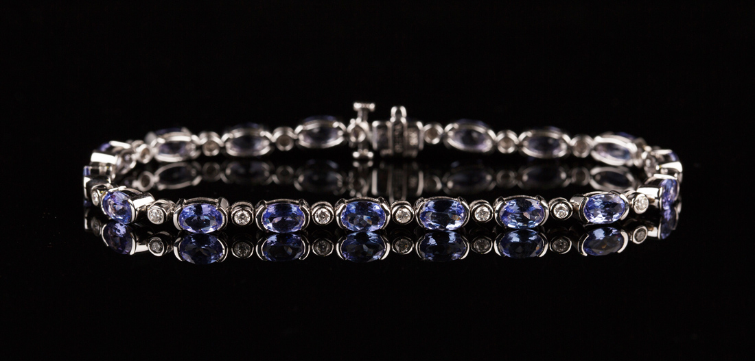 An 18ct white gold, tanzanite and diamond bracelet, mounted with a row ...