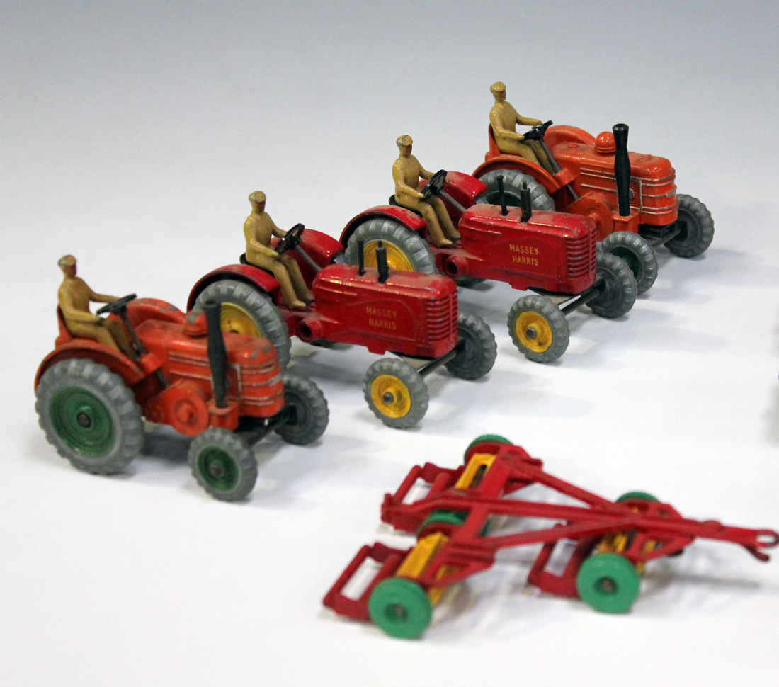 A collection of Dinky Toys tractors, vehicles and farm implements, including two No. 300 Massey Harr