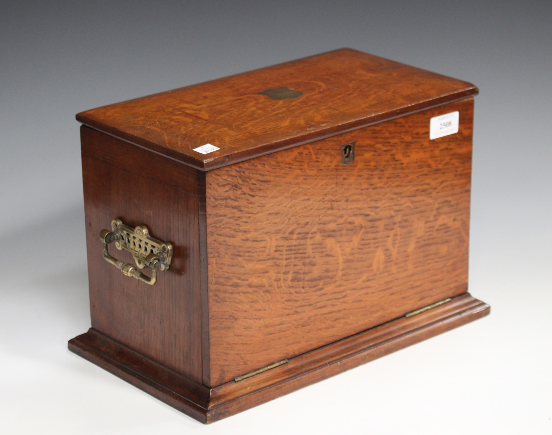 A late Victorian oak stationery box, the hinged lid and fall front