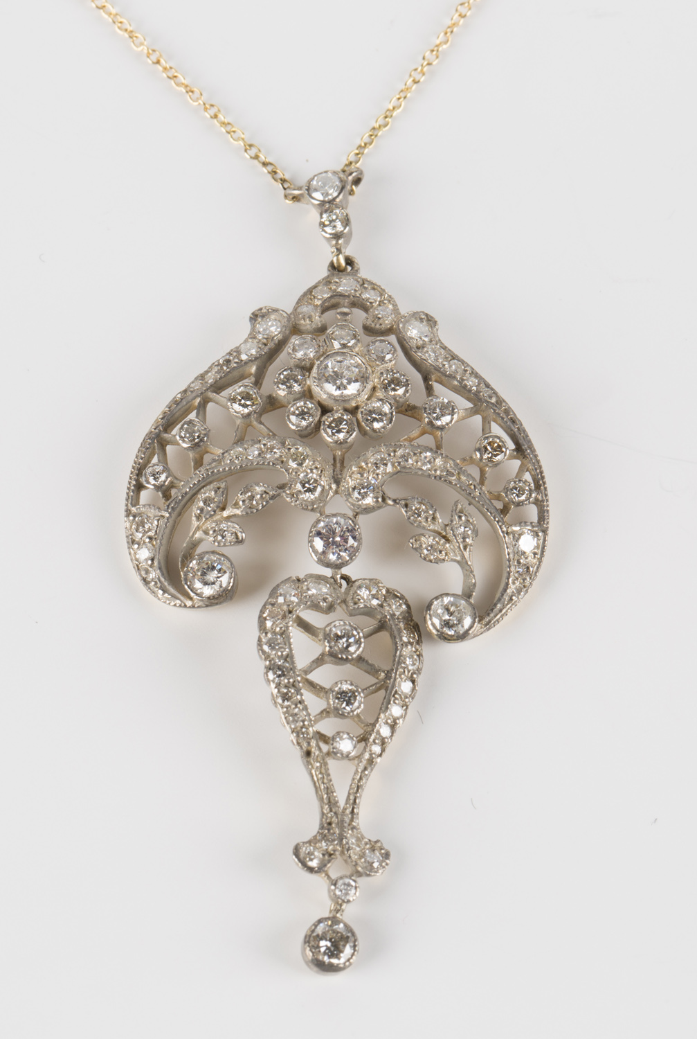A diamond pendant necklace in a scroll pierced openwork and foliate ...