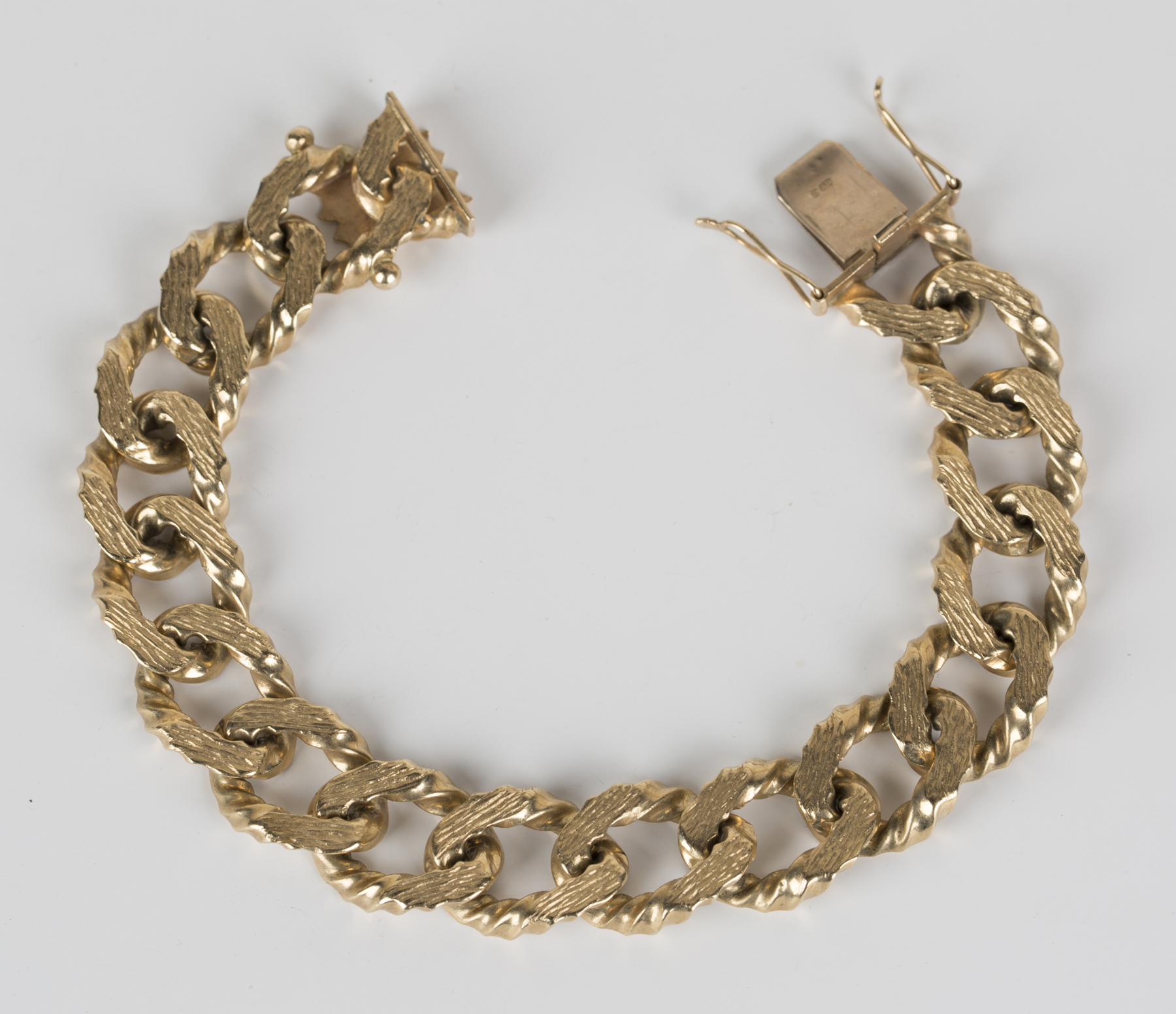 Download A 9ct gold curblink bracelet in a bark textured link ...