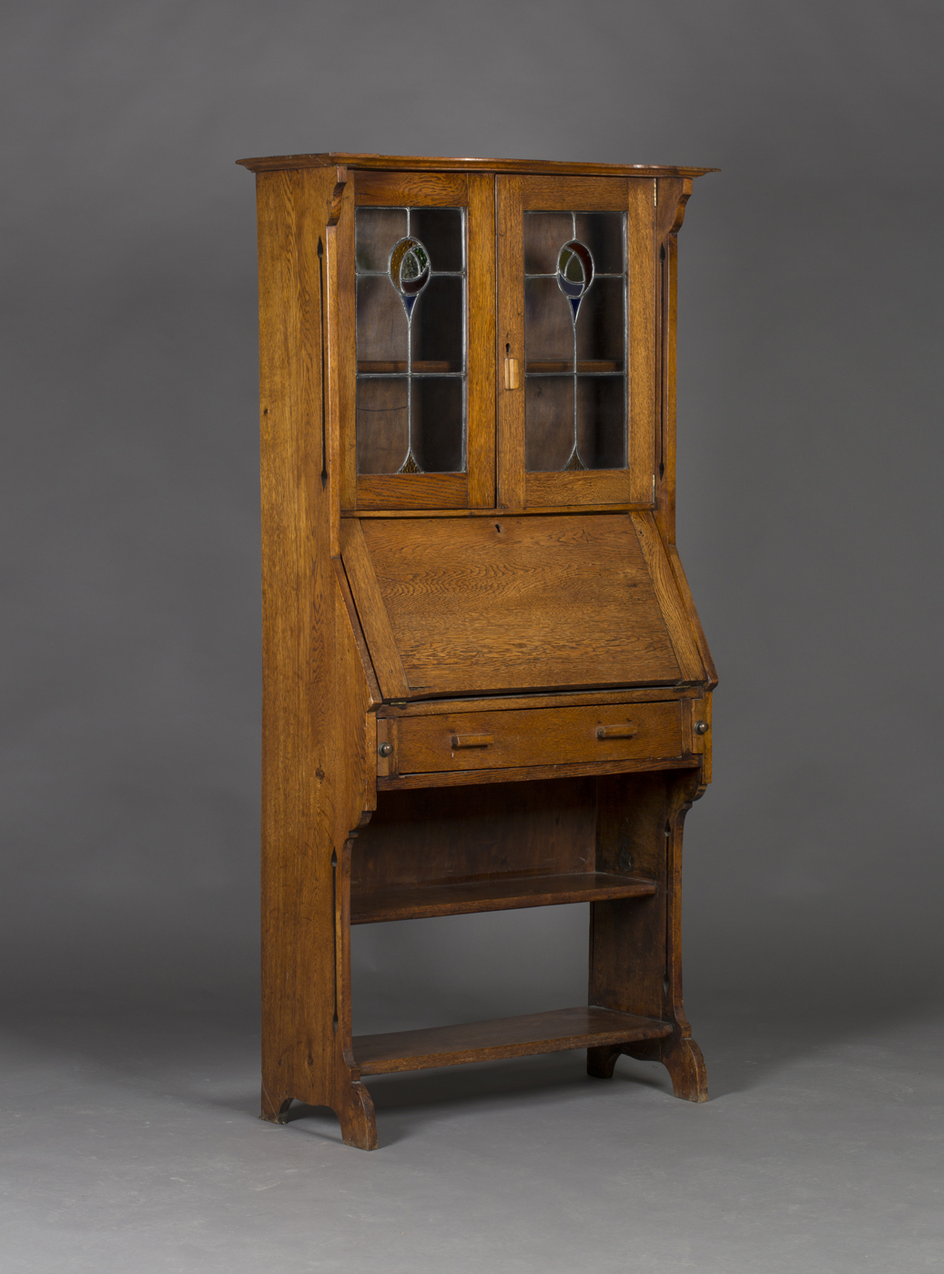 An Edwardian Arts and Crafts oak bureau bookcase the canopy