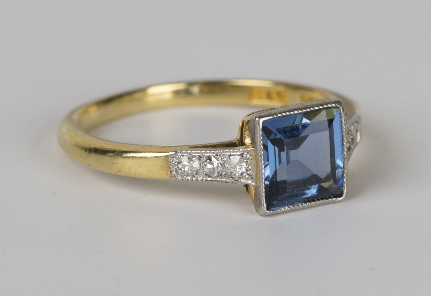 A gold, sapphire and diamond ring, mounted with the square step cut ...