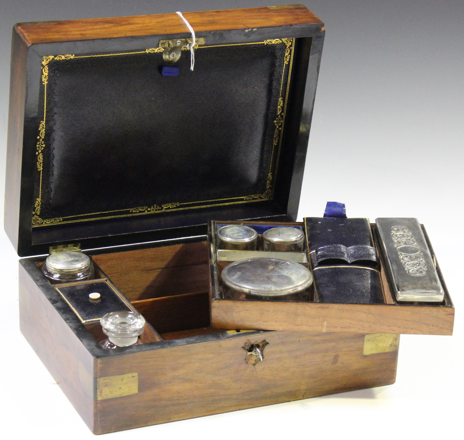 A late Victorian walnut and brass bound travelling vanity box, the ...