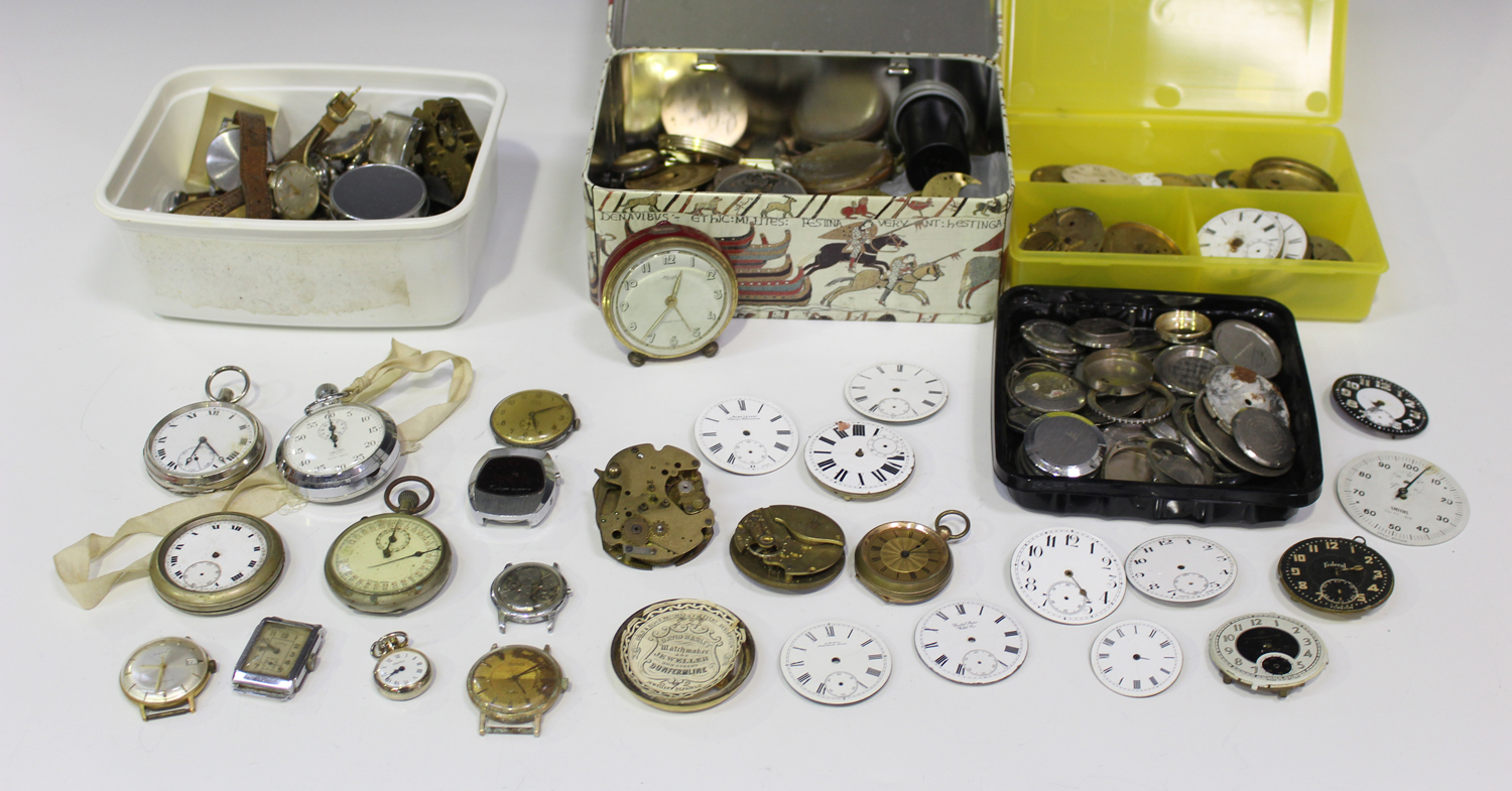 A collection of pocket watch and wristwatch movements and parts ...