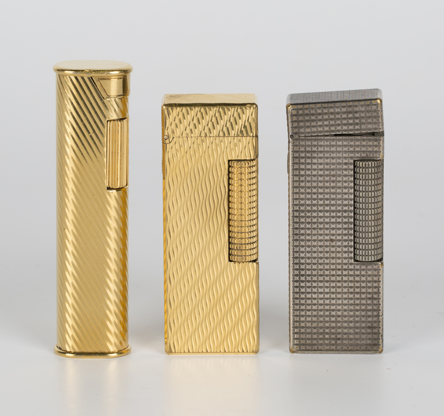 To grader anekdote Ægte A Dunhill silver plated rectangular gas lighter and two Dunhill gold plated  gas lighters.