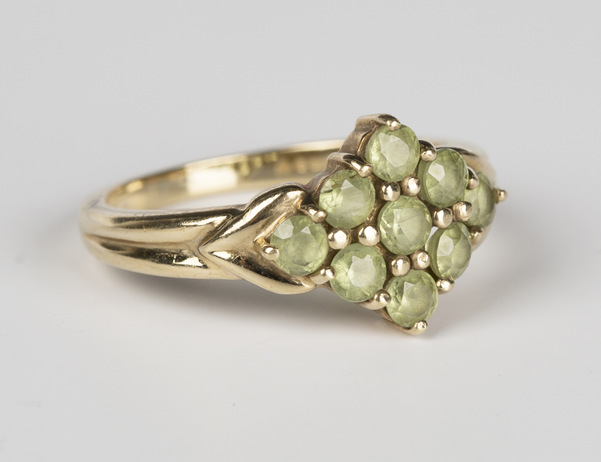 A 9ct gold and pale green gemstone set nine stone cluster ring in a ...