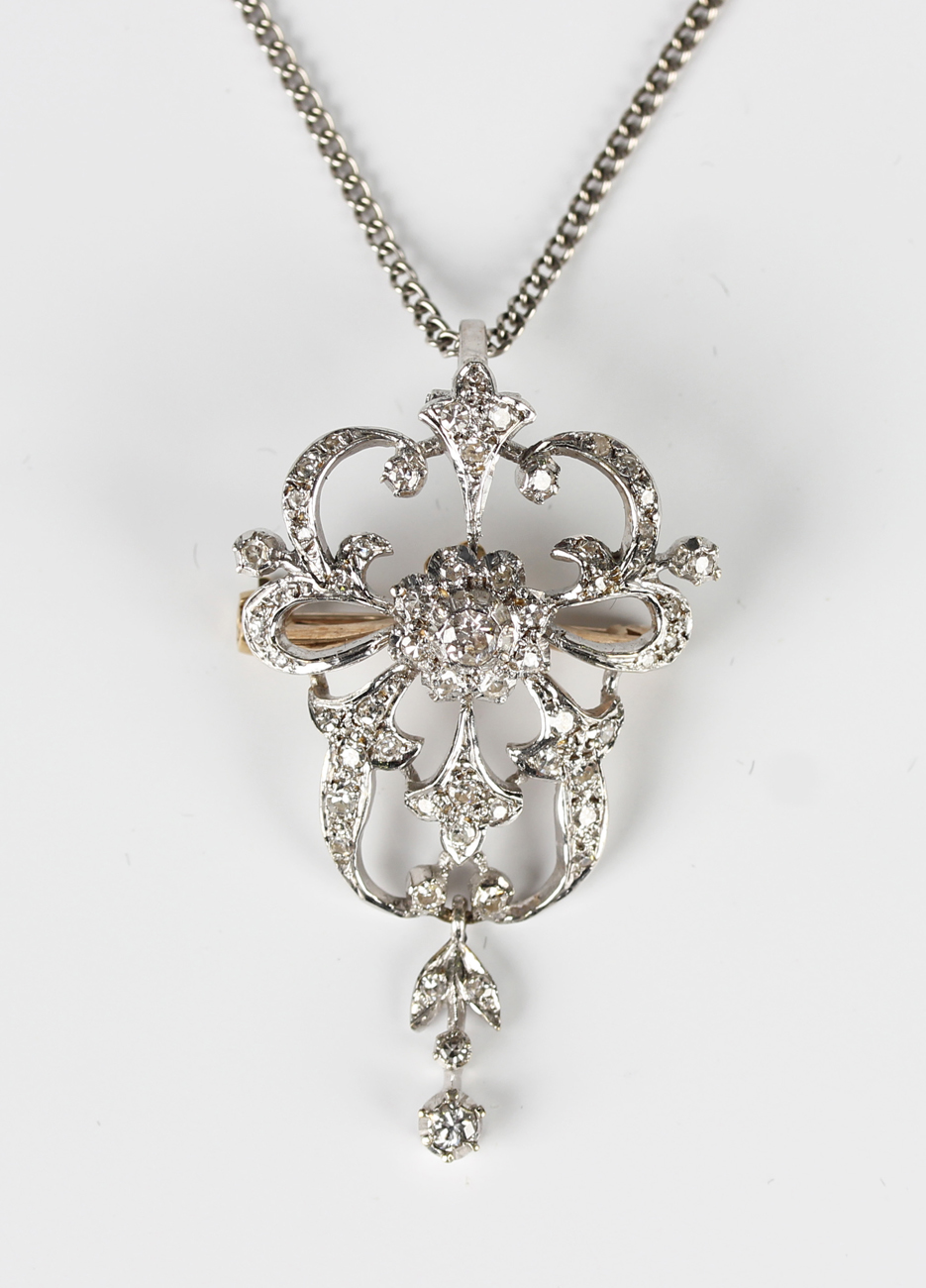 A diamond pendant brooch in a scroll pierced design, in the late 19th ...