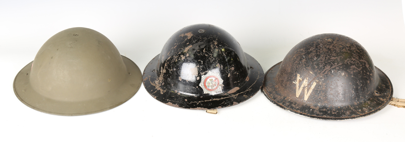 A group of three mid-20th century Brodie helmets, each detailed 'W ...