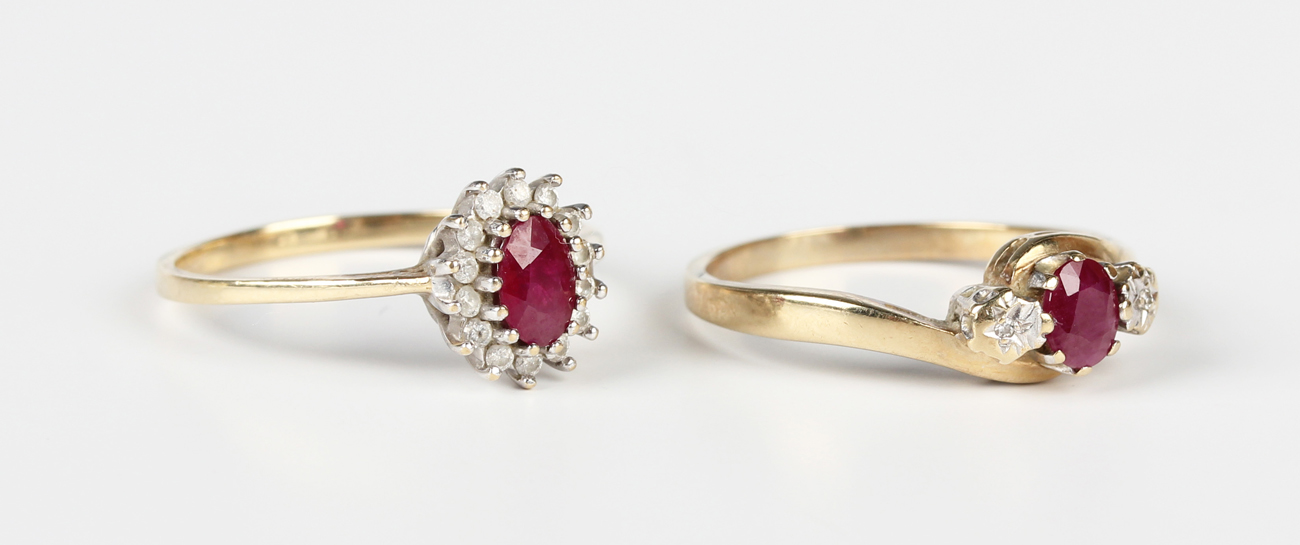 A 9ct gold ring, claw set with an oval cut ruby between two circular ...
