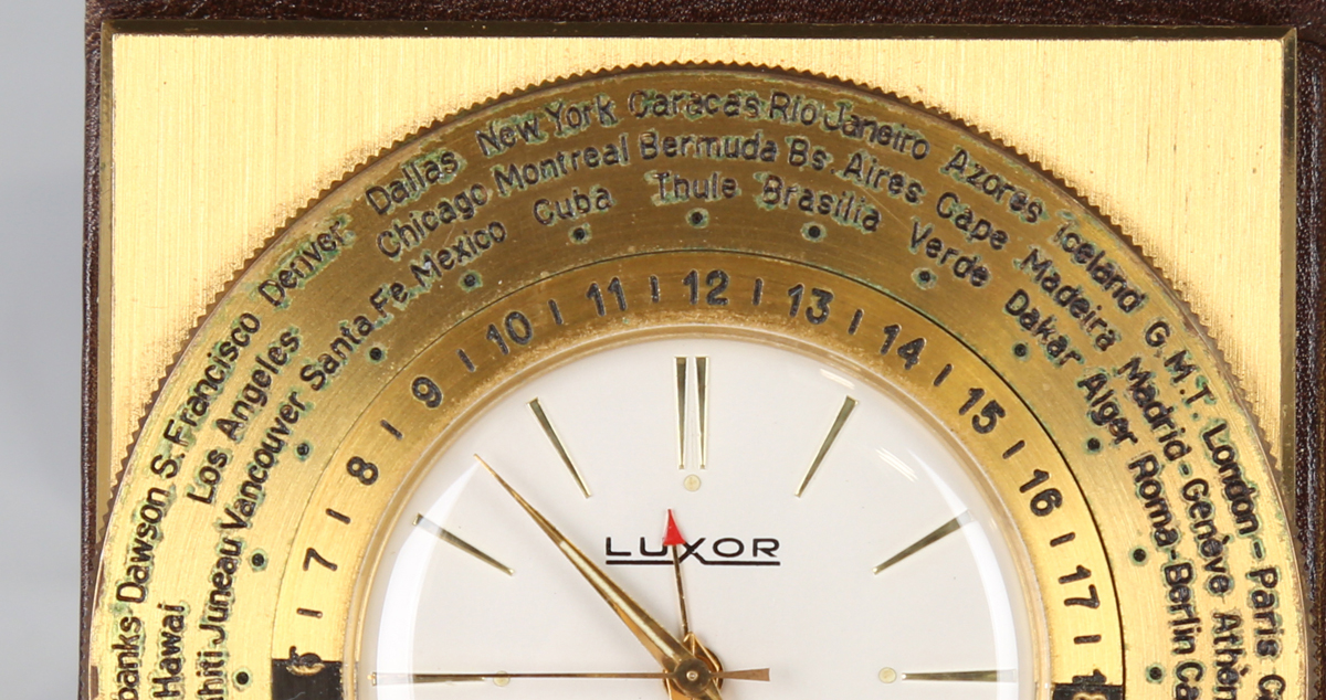 A Luxor brass cased world time travelling alarm clock, the signed